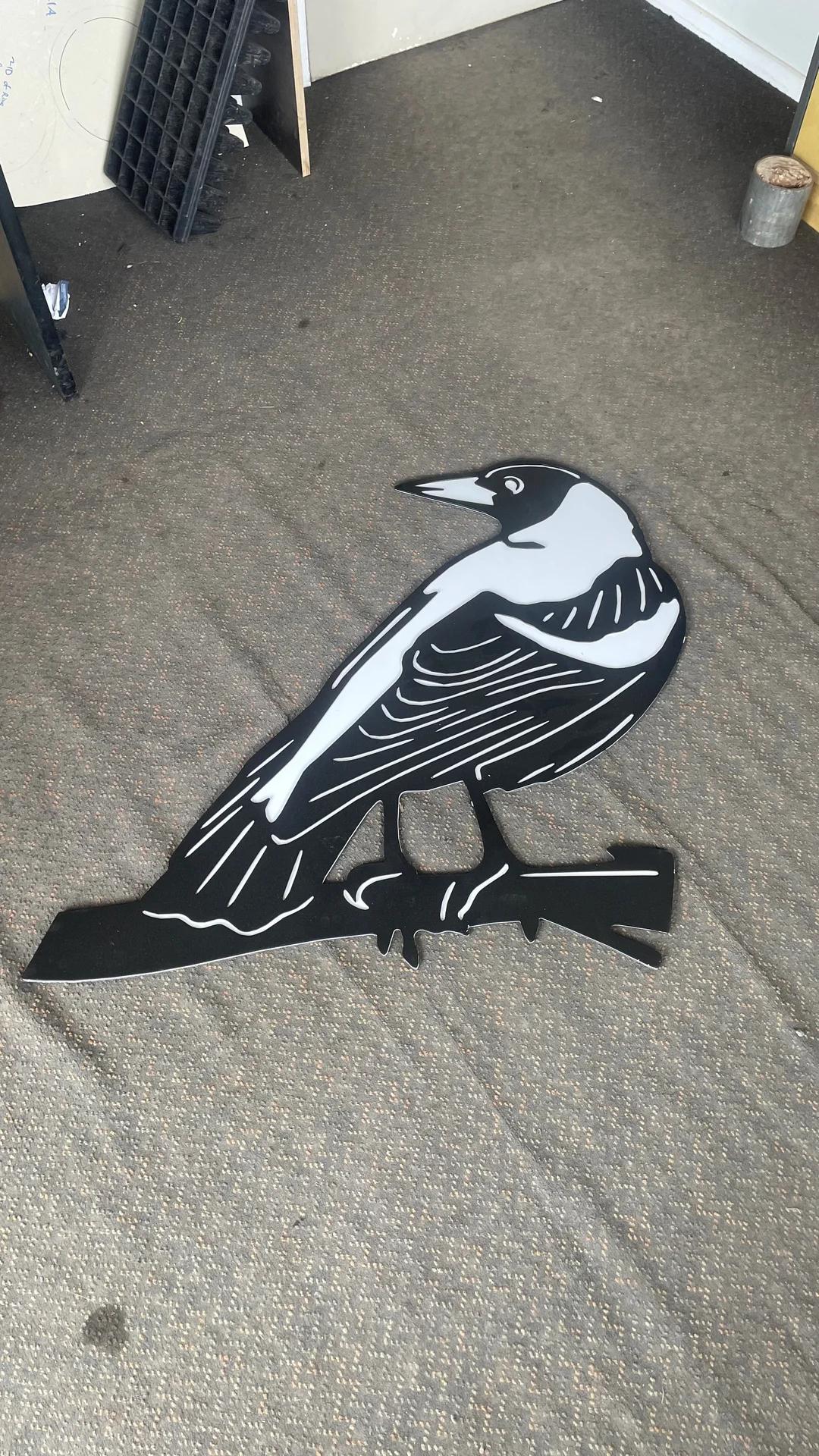 Laser cut steel magpie on a branch, painted black and white
