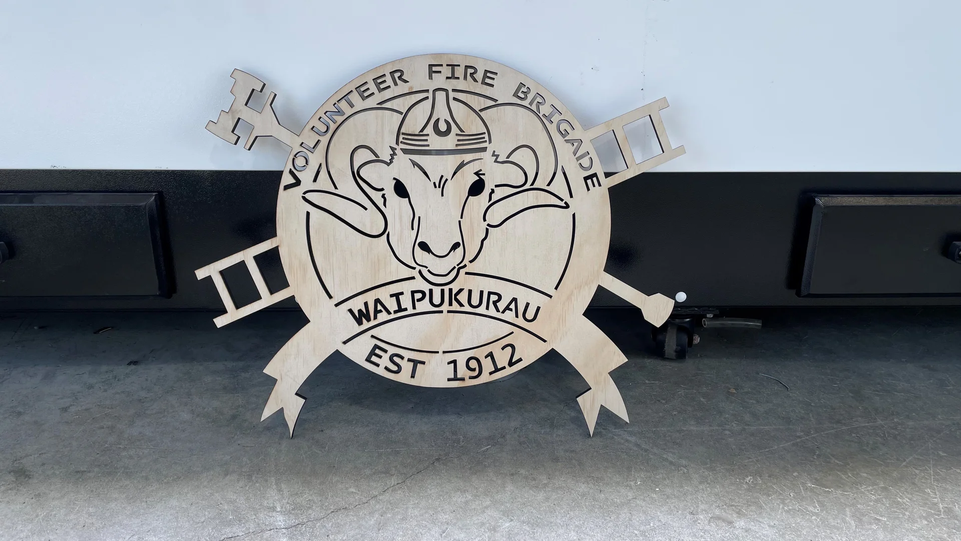 Laser cut plywood sign for the Waipukurau Volunteer Fire Brigade, with a ram's head, ladders and EST 1912