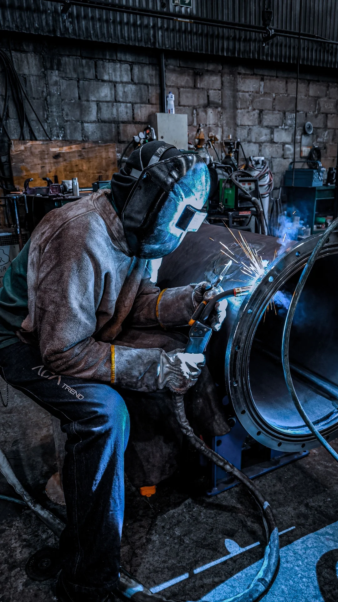 Welder at work under a welding helmet