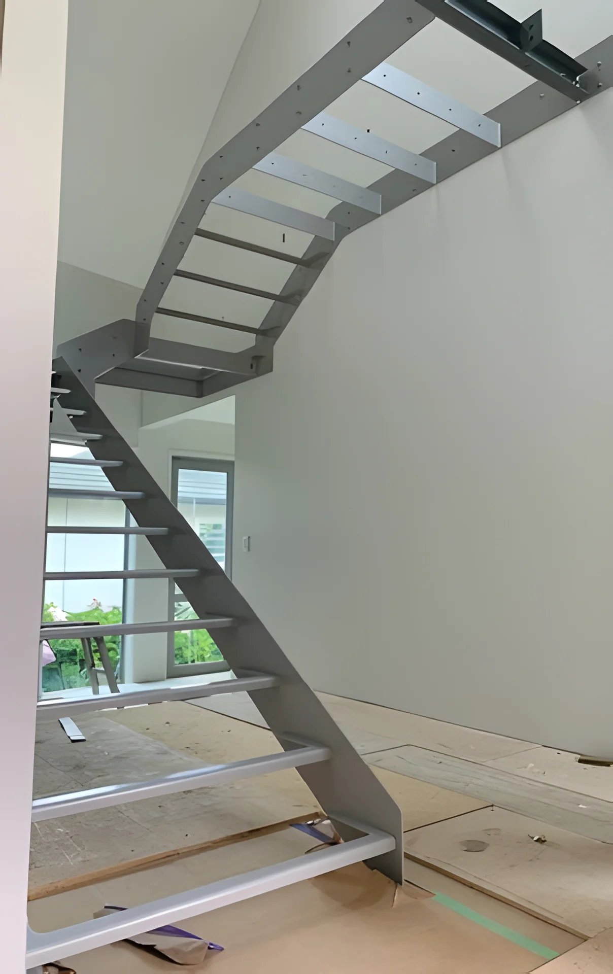 Open-tread steel staircase with a landing, installed in a new home